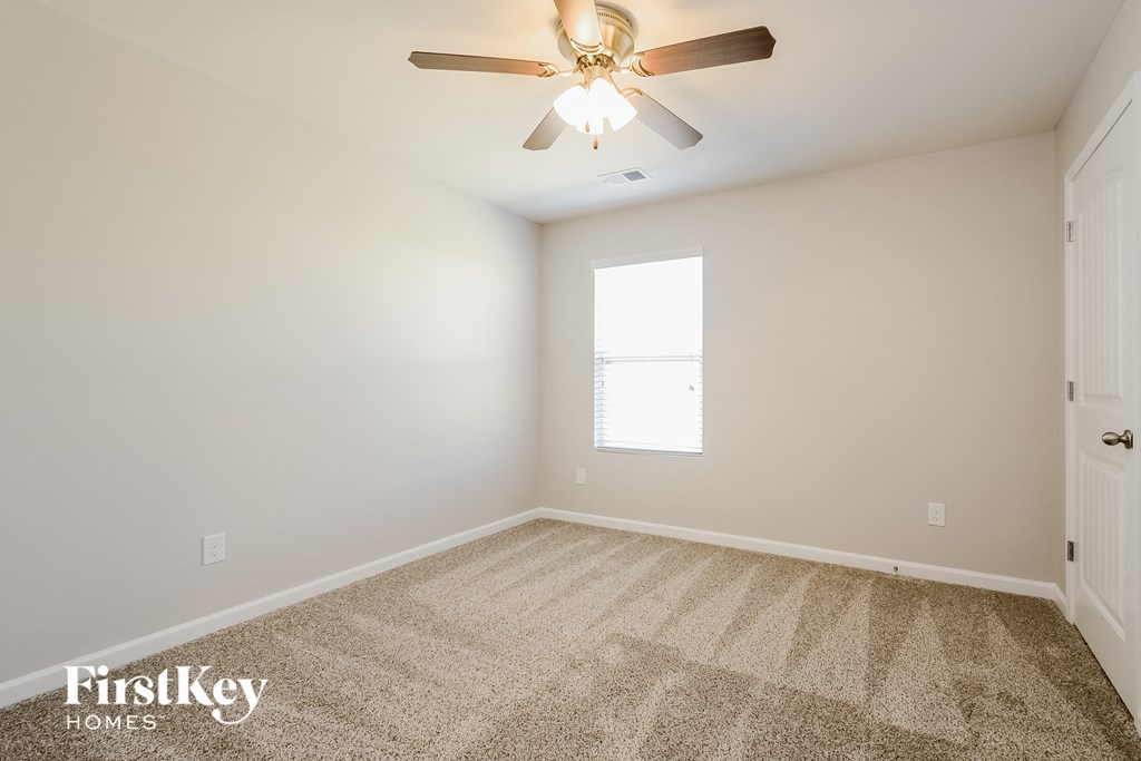 a bedroom with carpet and a ceiling fan