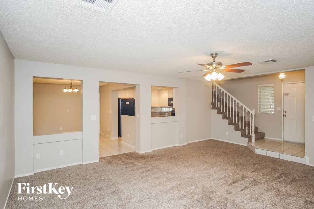 A spacious living room with a staircase leading to the upper floor.