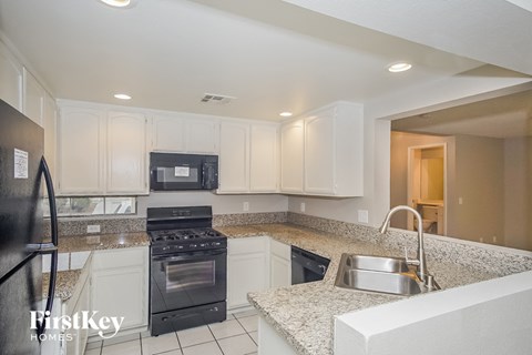 A kitchen with granite countertops and white cabinets.