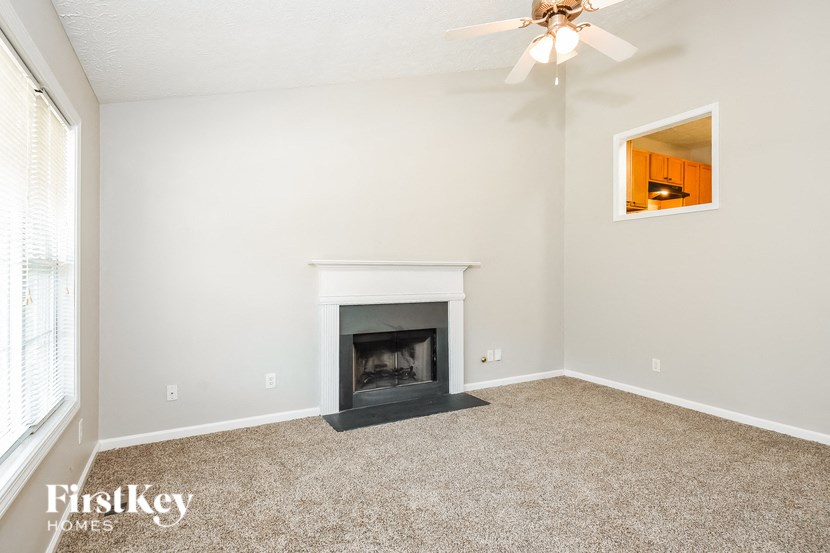 a living room with a fireplace and a ceiling fan