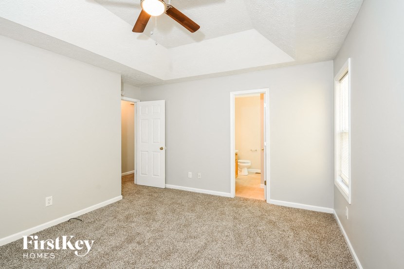 a living room with carpet and a ceiling fan