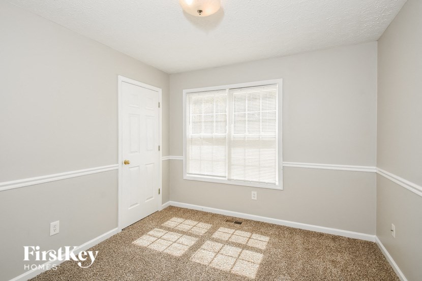 a bedroom with white walls and carpet and a white door