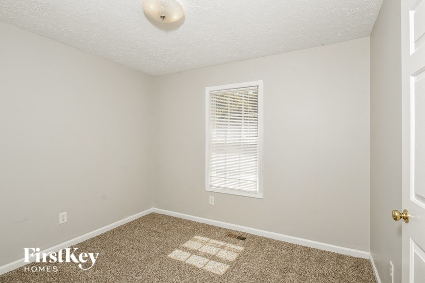 a bedroom with a carpeted floor and a window
