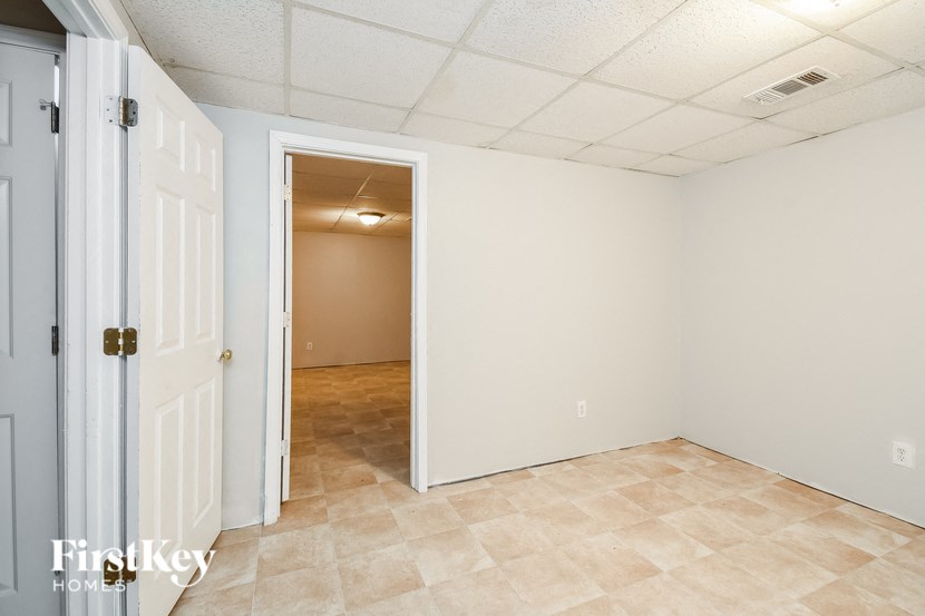the living room and dining room of a home with white walls and tile flooring