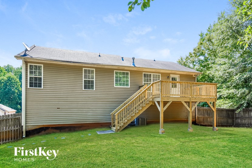 the back of a house with a deck and a wooden staircase