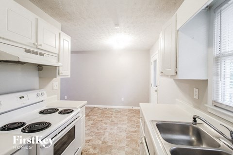 a white kitchen with white appliances and white cabinets