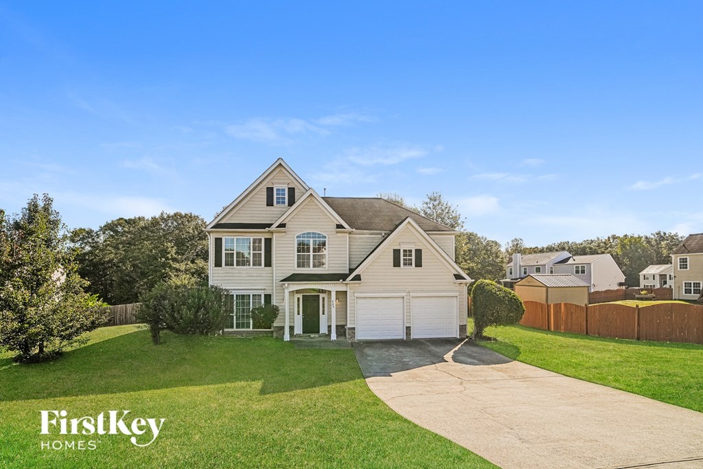 A house with a driveway and a garage is for sale by FirstKey Homes.