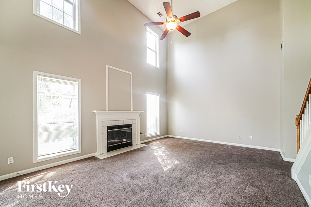 A spacious room with a fireplace and a ceiling fan.