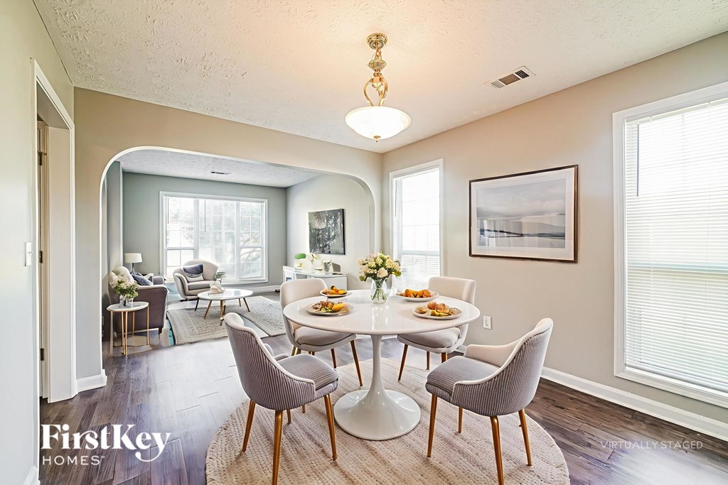 A dining room with a round table and chairs.