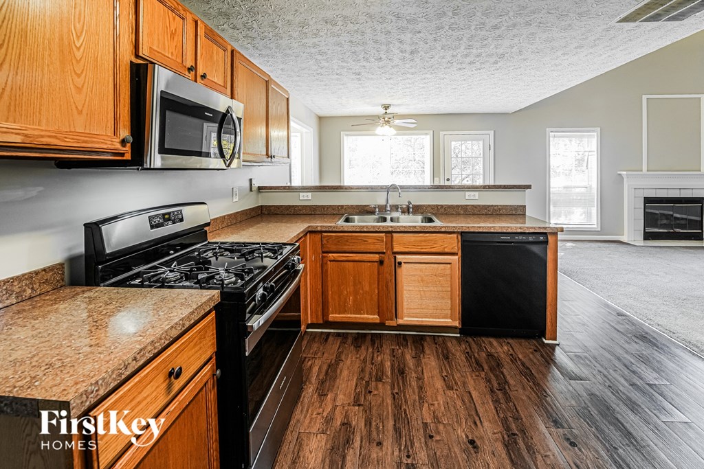 A kitchen with wooden cabinets and a black stove top oven.