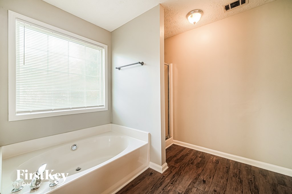 A bathroom with a tub and a window.