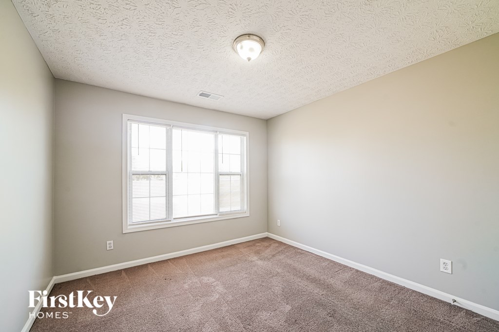 A room with a carpeted floor and a window.