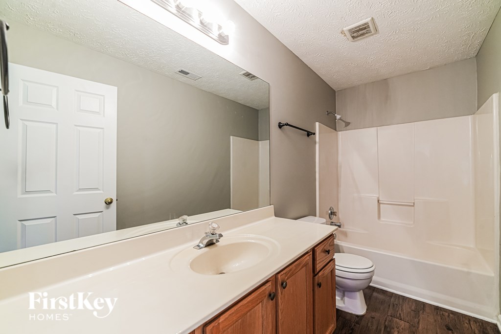 A bathroom with a white sink and a white toilet.
