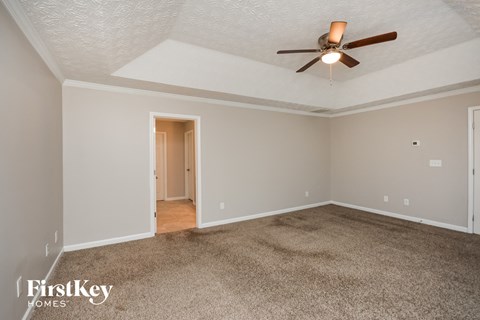 a living room with carpet and a ceiling fan