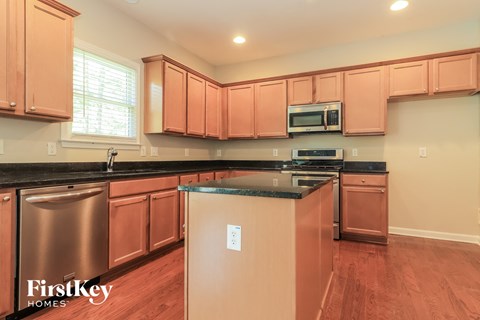 A kitchen with wooden cabinets and a black countertop.