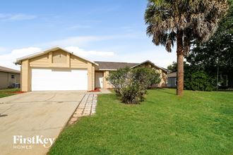 a house with a garage and a palm tree