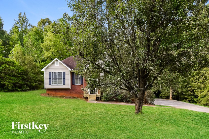 a small white house with a tree in front of it