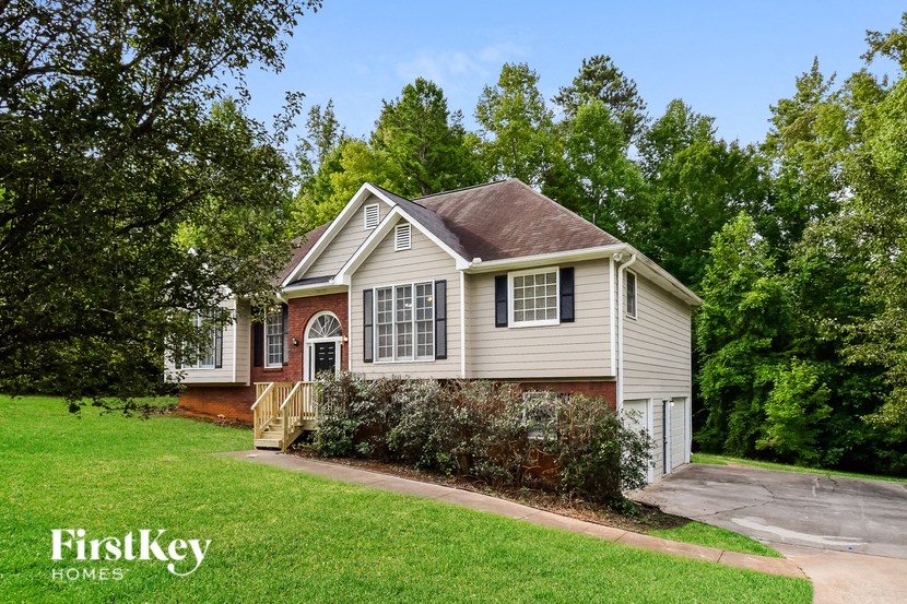 a white house with a yard and trees