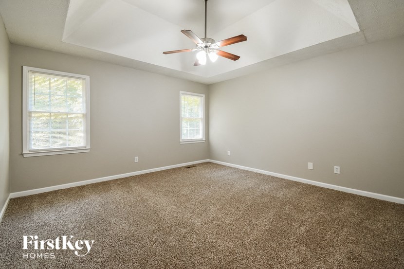 a room with carpet and a ceiling fan