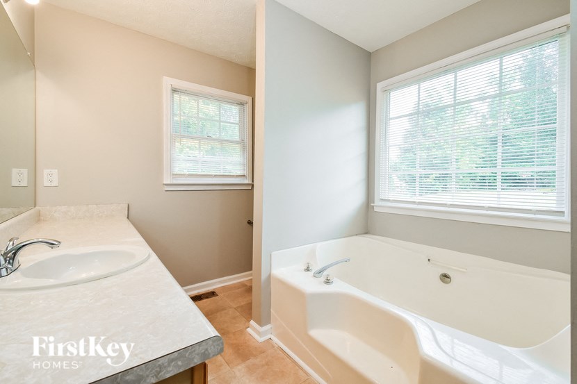 a bathroom with a tub and a sink and a window