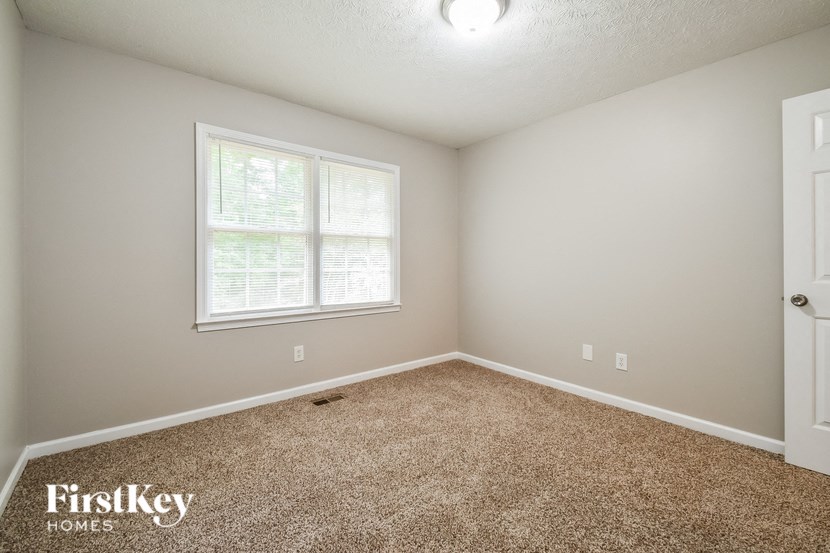 a bedroom with a carpeted floor and a window