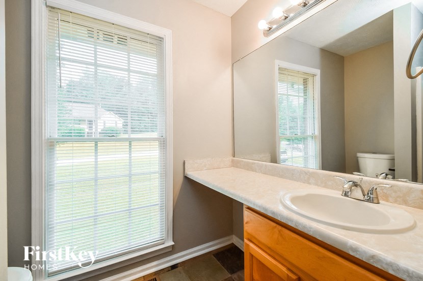 a bathroom with a sink and a mirror and a window