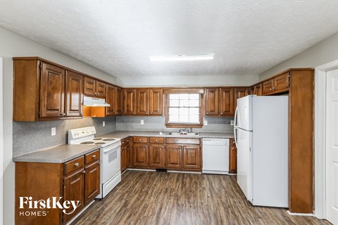 A kitchen with wooden cabinets and a white refrigerator.
