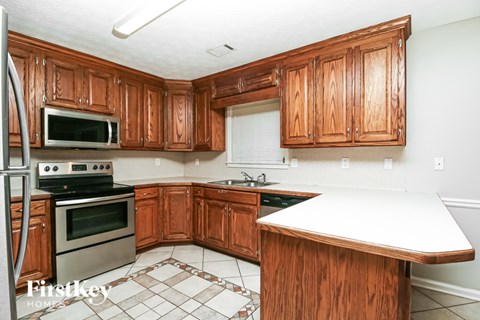 A kitchen with wooden cabinets and a white counter top.