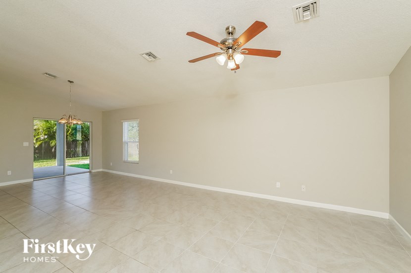 a empty living room with a ceiling fan