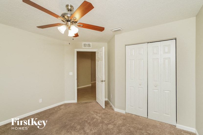 a bedroom with a ceiling fan and a closet