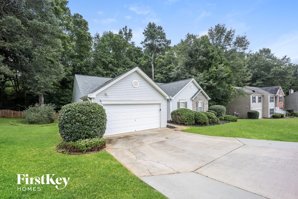 a white house with a white garage door and a driveway