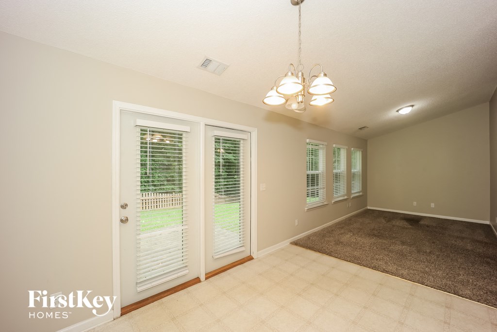 a dining room with a carpeted floor and doors to a patio