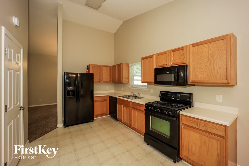 a kitchen with black appliances and wooden cabinets