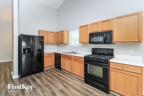 A kitchen with wooden cabinets and black appliances.