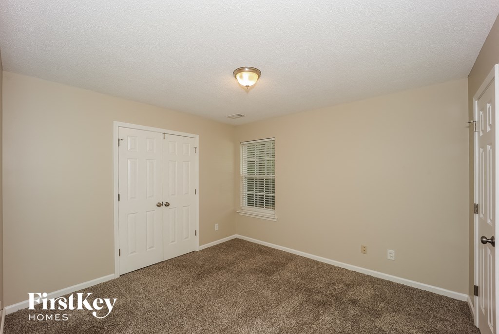 a bedroom with carpet and a white door