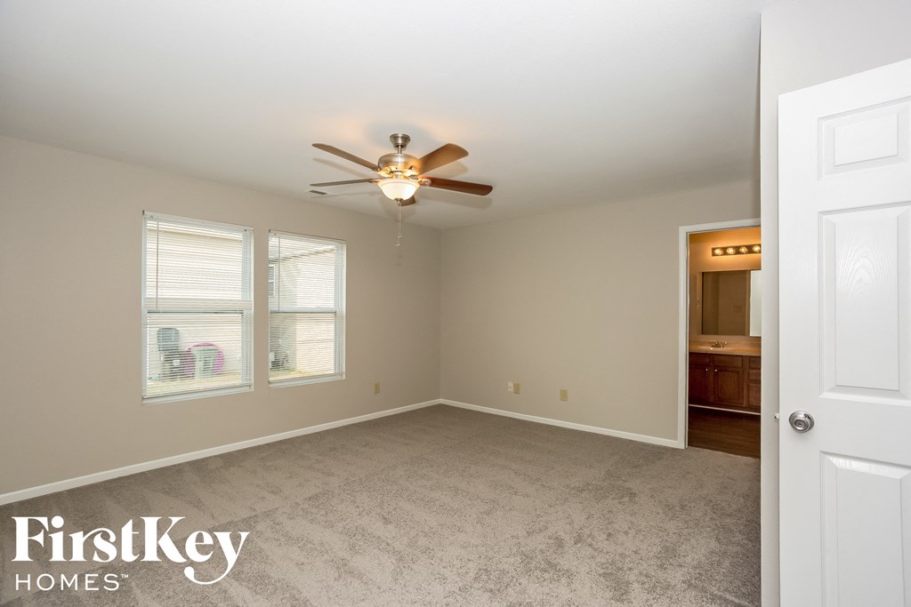 a bedroom with carpet and a ceiling fan