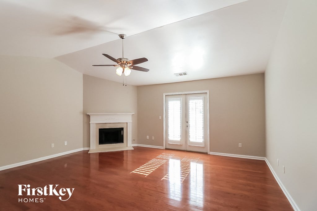 a living room with a fireplace and a ceiling fan