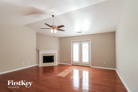 a living room with a fireplace and a ceiling fan