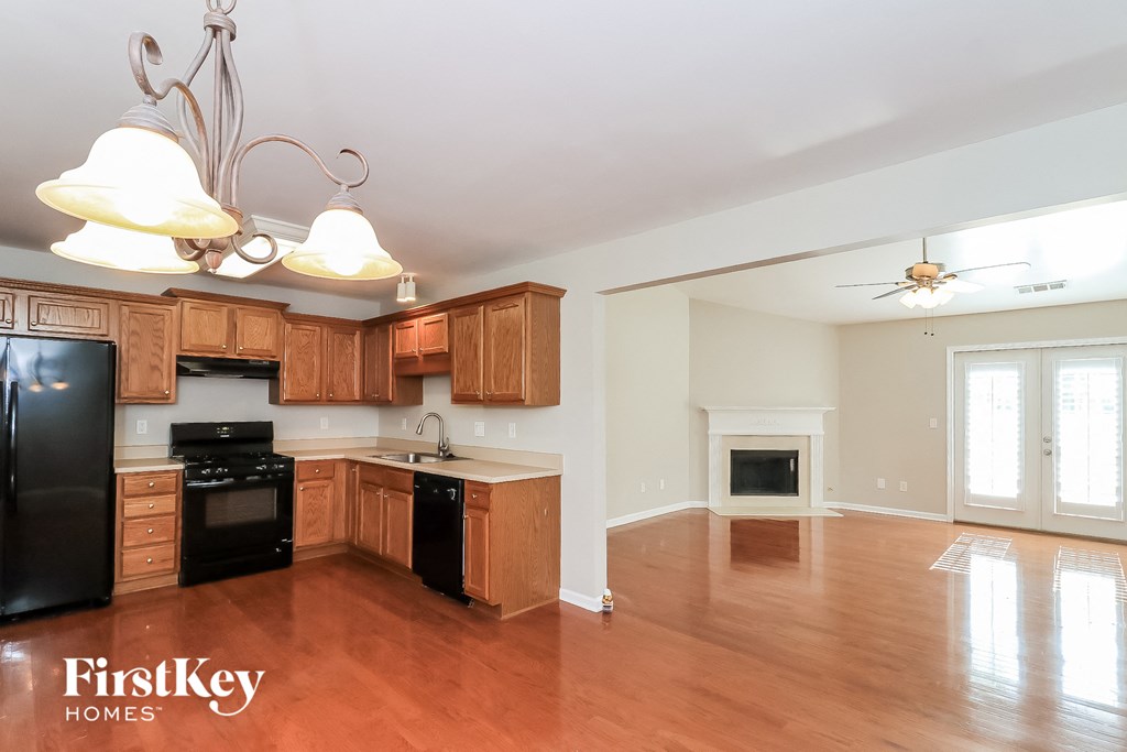 a kitchen and living room with wood flooring and a fireplace