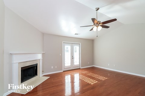 a living room with a fireplace and a ceiling fan