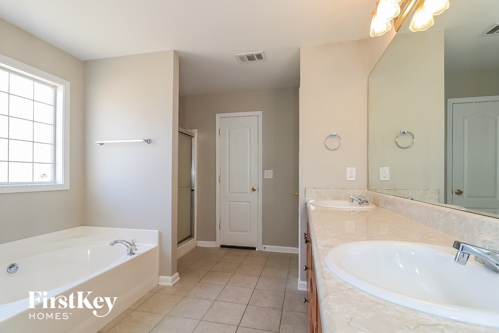 a bathroom with a tub and a sink and a mirror