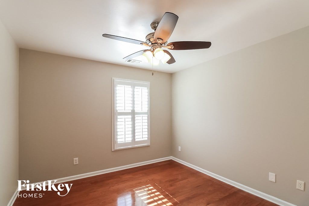 the master bedroom has a ceiling fan and hardwood floors