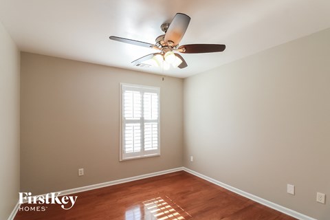 the master bedroom has a ceiling fan and hardwood floors