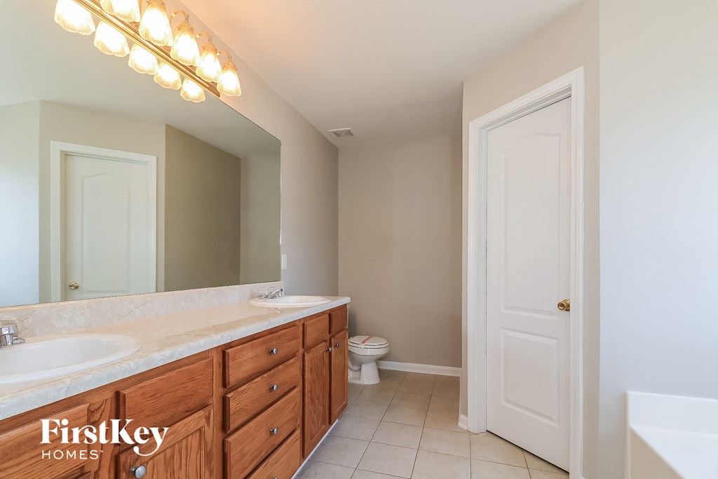a bathroom with two sinks and a toilet and a mirror