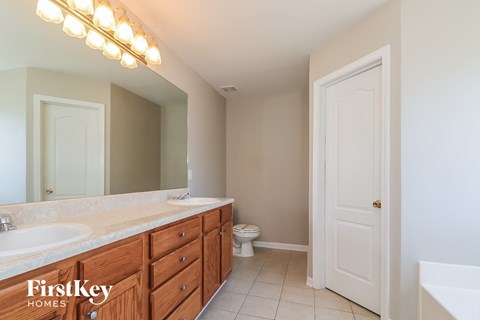 a bathroom with two sinks and a toilet and a mirror