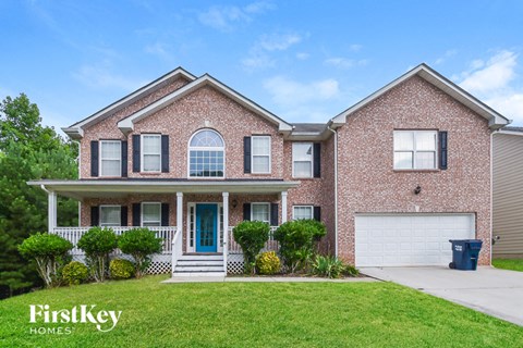 a brick house with a blue door and a white garage door