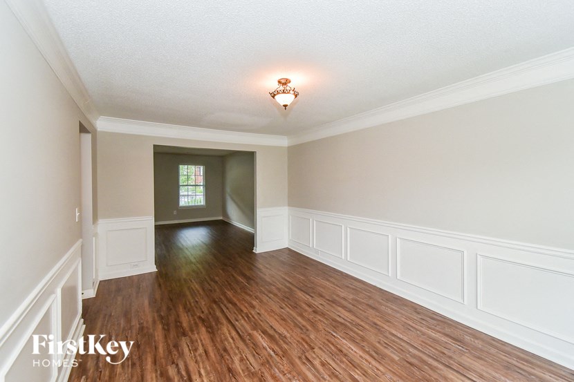 an empty living room with wood floors and white walls