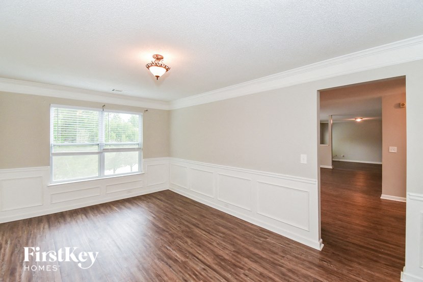 an empty living room with wood flooring and a window