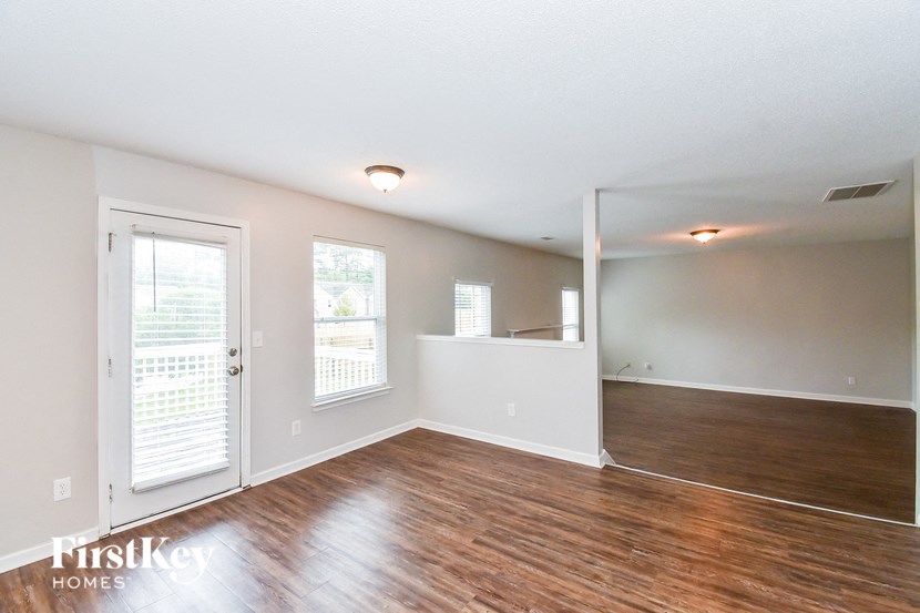 the living room and dining room with wood floors and white walls