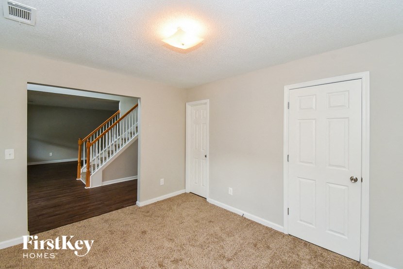 a living room with a staircase and a white door